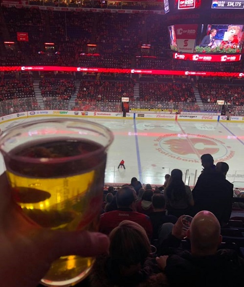 Photo of a Calgary Flames fan drinking beer at Scotiabank Saddledome during a Calgary Flames game.