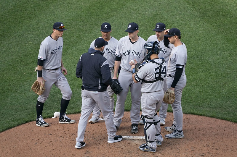 Photo of New York Yankees players meeting on the mound.