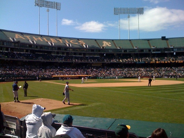 Photo of an Oakland Athletics game at Oakland Coliseum with the tarp covering the upper level in the background.
